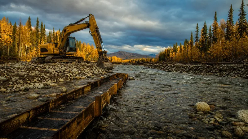 Gravel creek bed with a sluice box and yellow excavator, How to Start a Placer Mining Business in Alaska